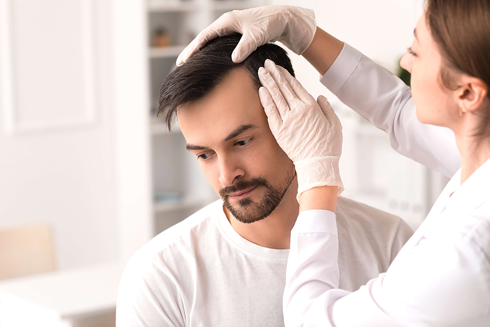 A healthcare professional wearing gloves tends to a patient’s hairline in a bright, modern clinic environment.
